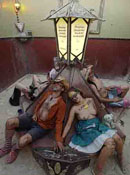 Four participants wearing colorful sunglasses recline in seats with their backs to a decorative lamp post.