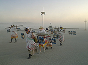 A group of five tunicked lamplighters brave a dust storm to light the city.